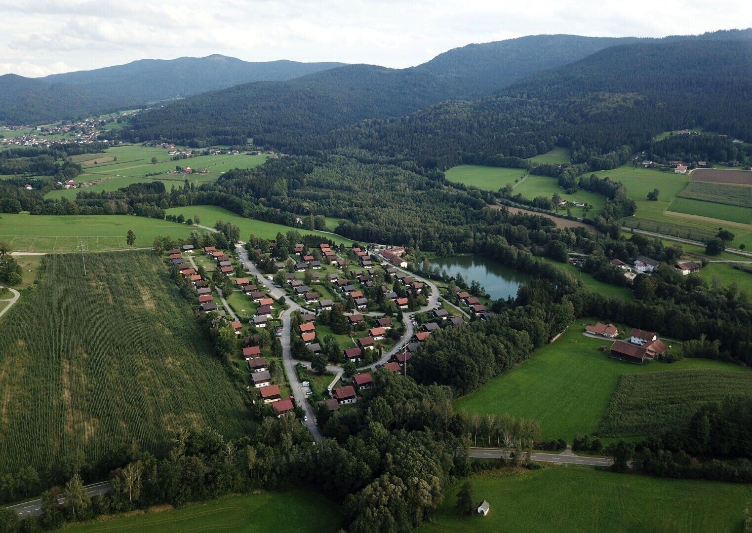 Ett flygbildsbild av ett bostadsområde med hus, vägar och omgivande grönska.