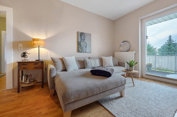 Une chambre à coucher avec un lit, une table de chevet, une lampe, une œuvre d’art et une vue par la fenêtre.