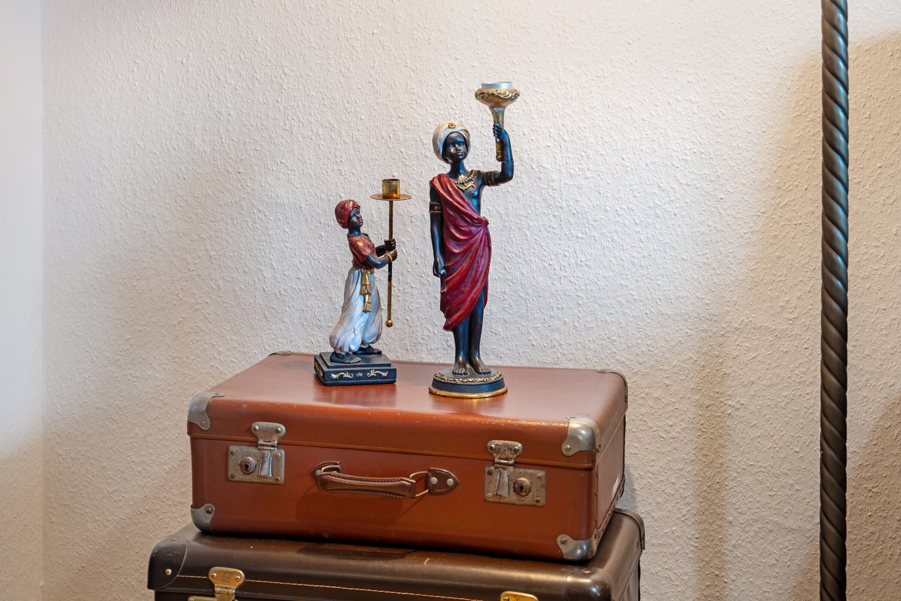 Ein Stapel alter Koffer mit Figuren darauf.