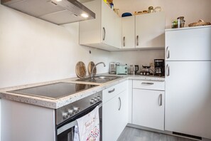 Een koelkast, een oven, een kookplaat, een vaatwasser