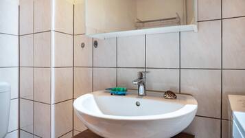 A bathroom with a white sink, a mirror, and a towel rack.