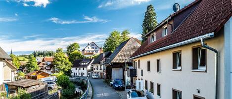 En smal gade med traditionelle bygninger, en flod på den ene side og en klar blå himmel.