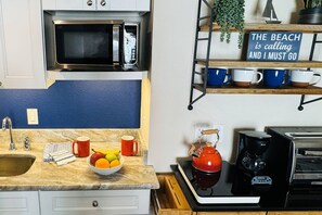 Fridge, microwave, coffee/tea maker, cookware/dishes/utensils