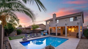 A modern house with a swimming pool, outdoor seating, and a patio area. - Desert Playhouse | Pool & Hot Tub • Arcade • Golf (Chandler)