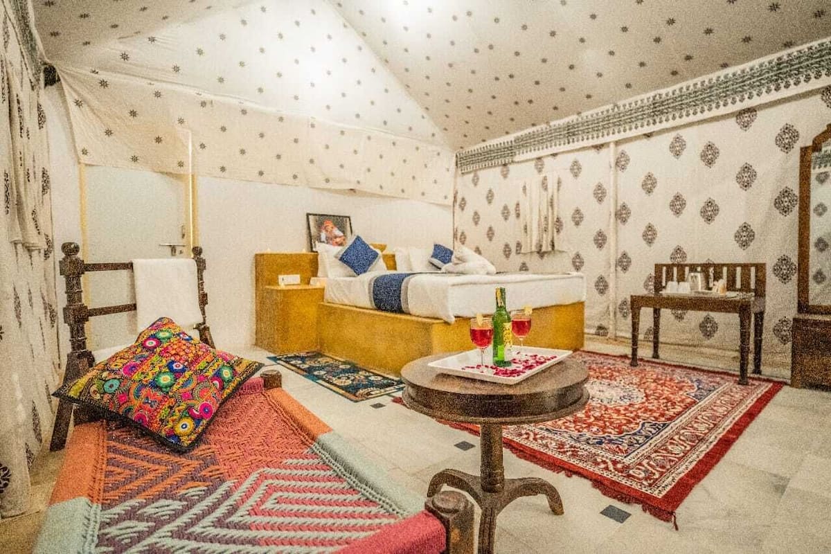 Une chambre avec un lit, une petite table avec des boissons et une chaise.