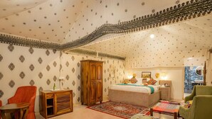 Een knus ingerichte kamer met een bed, een houten kast, een stoel, een tafel en een raam met uitzicht.
