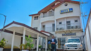 Un hotel con bar, restaurante y entrada cubierta.