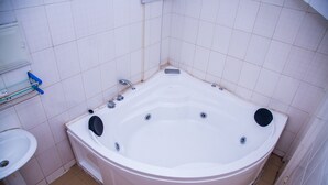 Un baño con una bañera blanca, un lavamanos y una zona de ducha.
