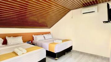 Habitación de hotel con dos camas, techo de listones de madera, paredes blancas y suelo de baldosas.