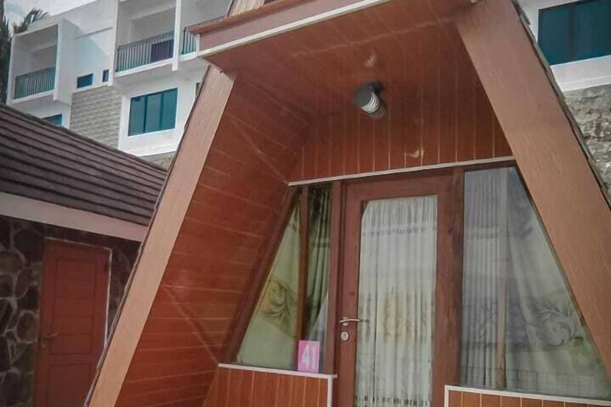 A triangular-shaped building with a wooden exterior and a tiled floor.