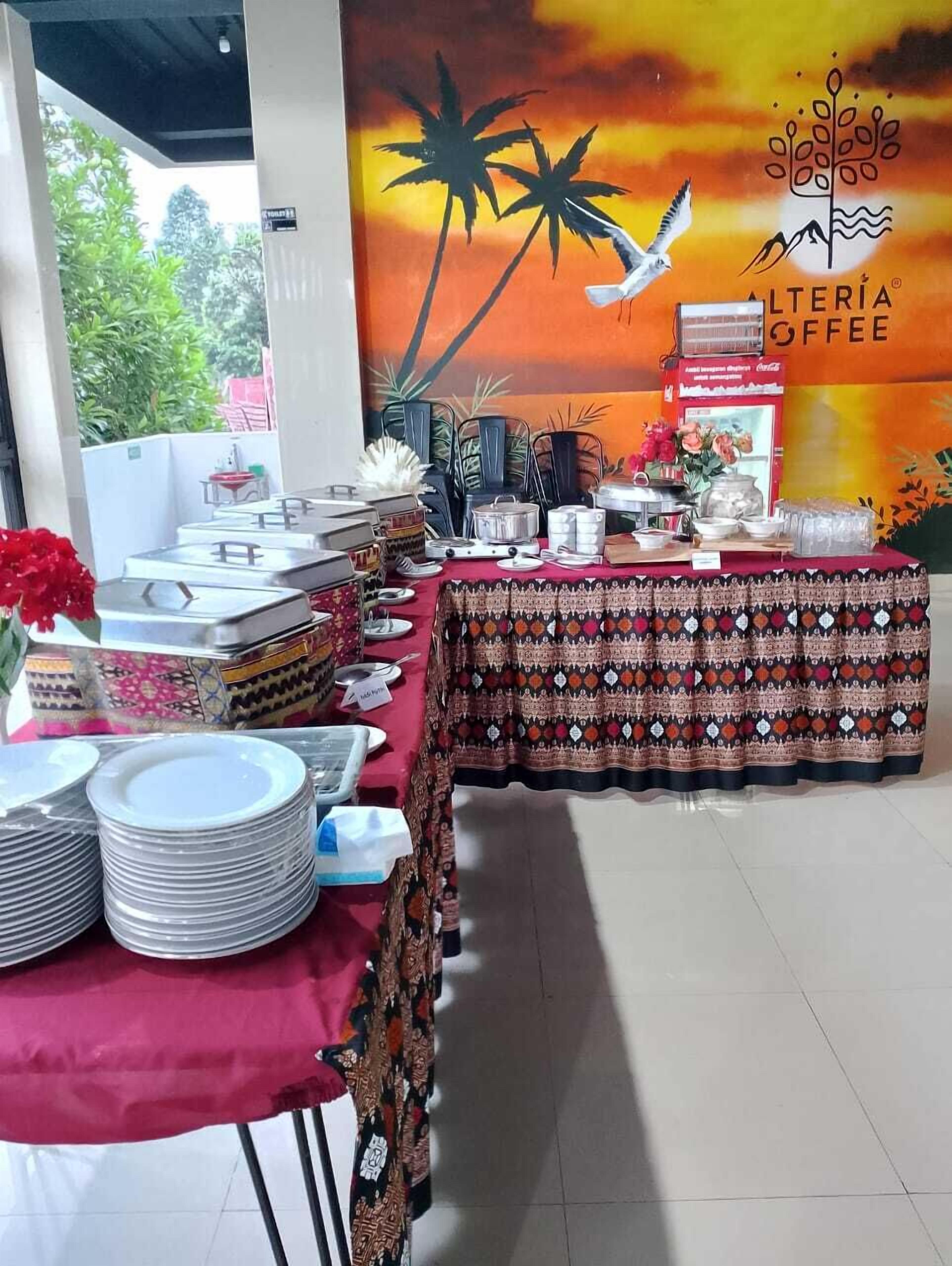 Un buffet dressé avec une nappe rouge, des assiettes et différents récipients contenant de la nourriture.