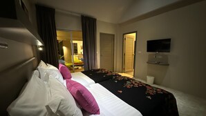Habitación de hotel con una cama, un televisor y vistas al comedor.