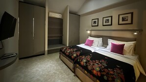 Un dormitorio con cama, televisor, armario e iluminación empotrada en el techo.