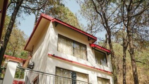 A two-story building with a red roof, large windows, and a balcony. - Tapovan Resorts (Kasauli)