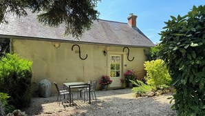 A rustic house with a gravel driveway, a small patio table, and chairs. - Idyllic Village Cottage With Hot Tub & Scenic Views (Mont-Saint-Jean)