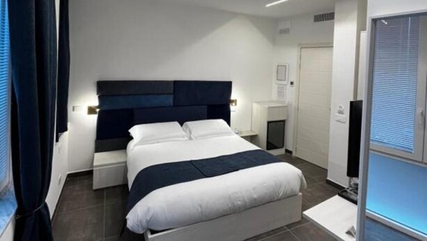 Un dormitorio moderno con una cama grande, mesitas de noche, un televisor de pantalla plana y un calentador integrado.