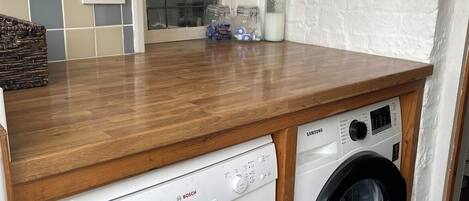 A compact kitchen with a Bosch dishwasher and a Samsung washing machine.