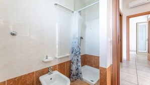 Un baño con ducha, lavamanos y bañera.