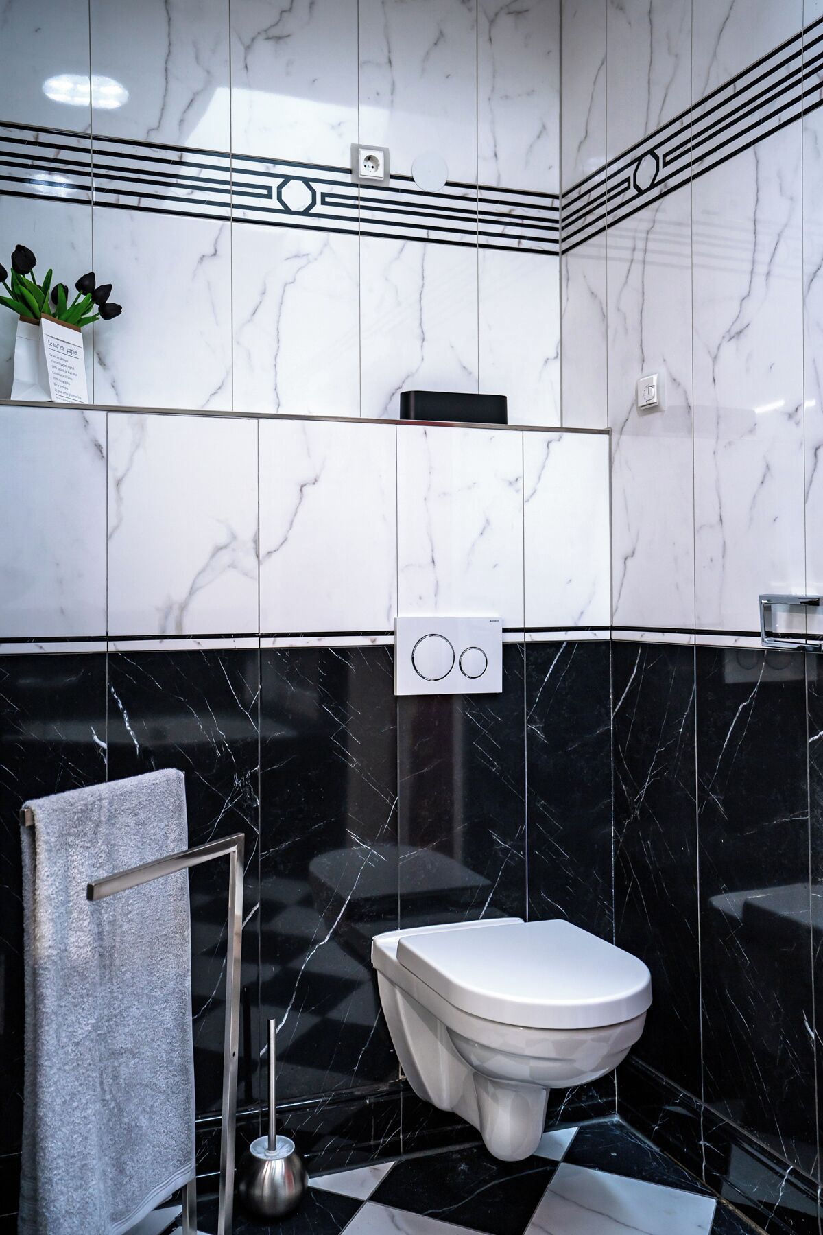 Een badkamer met toilet, handdoekhouder en wastafel.