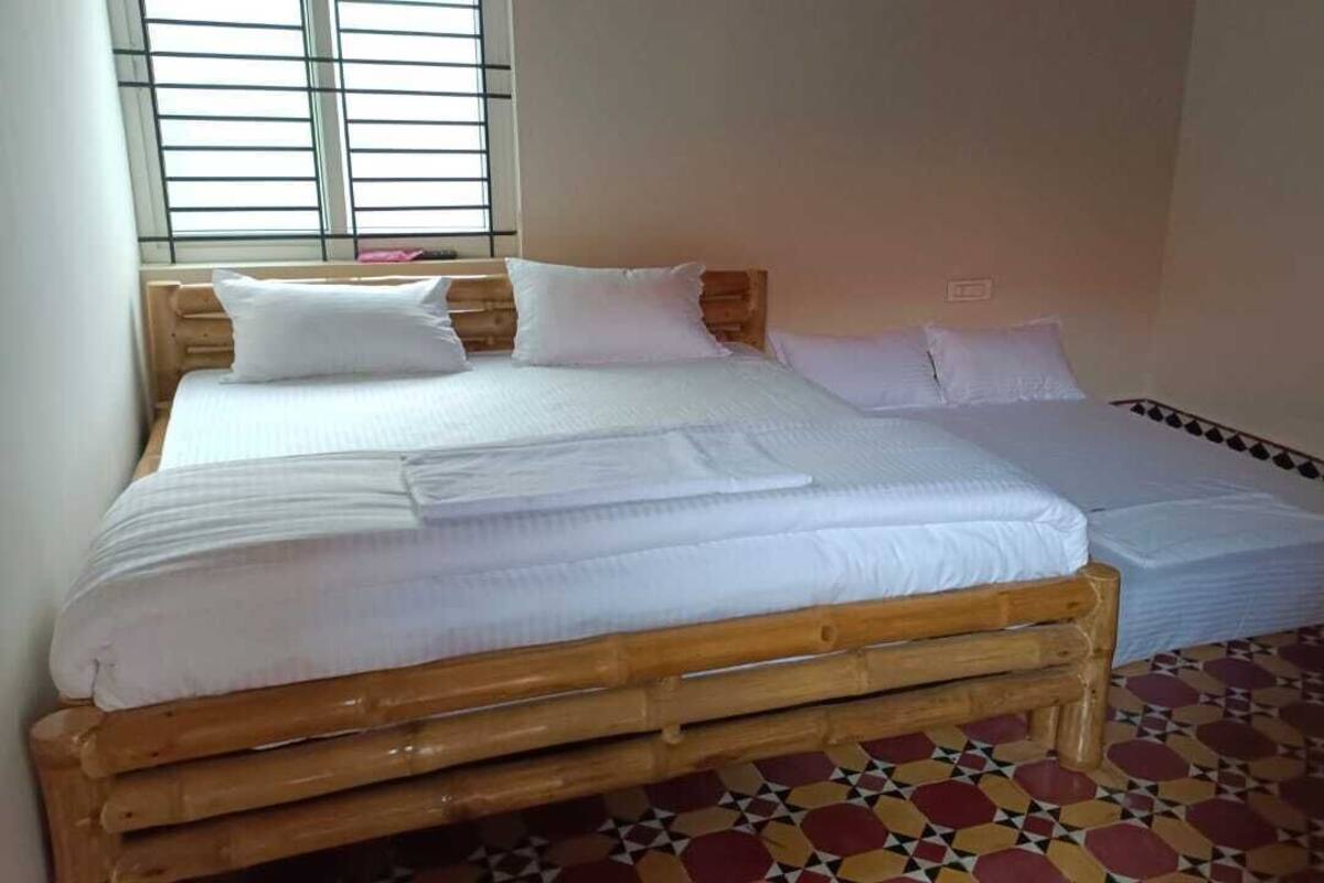 A room with a bed, a wooden headboard, and a patterned floor.