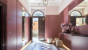 A hallway with a checkered floor, a mirror, and a shelf with flowers. - Contemporary Elegance: New 3-bedroom loft between Trastevere and the Vatican (Roma)