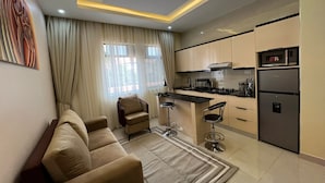 Una cocina moderna con zona de comedor, que incluye un sofá, sillas y una isla de cocina.