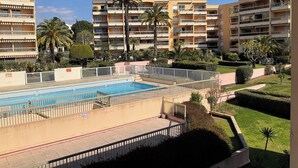 Zona de piscina con vista despejada a un edificio de varios pisos al fondo.