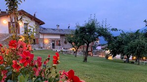 A stone building with a grassy yard and trees. - Alle Macine - Molino Maufet (Colico)