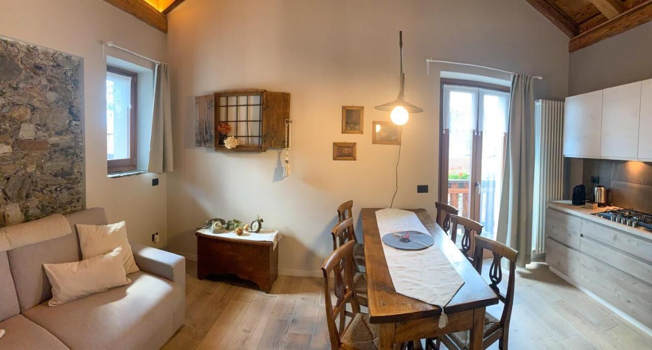 Un salon chaleureux avec une table à manger en bois, un canapé et un mur en pierre.