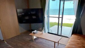 A living room with a flat-screen TV, a wooden coffee table, and a sofa. - Shima-shi kodate (Shima)