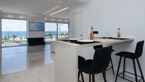 Una cucina moderna con un'isola grande, sgabelli da bar neri e vista sull'oceano.