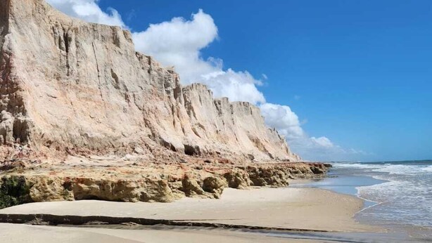 A beach with a sandy shore and a rocky cliff. - Pousada e Restaurante Lual do Parajuru (Beberibe)