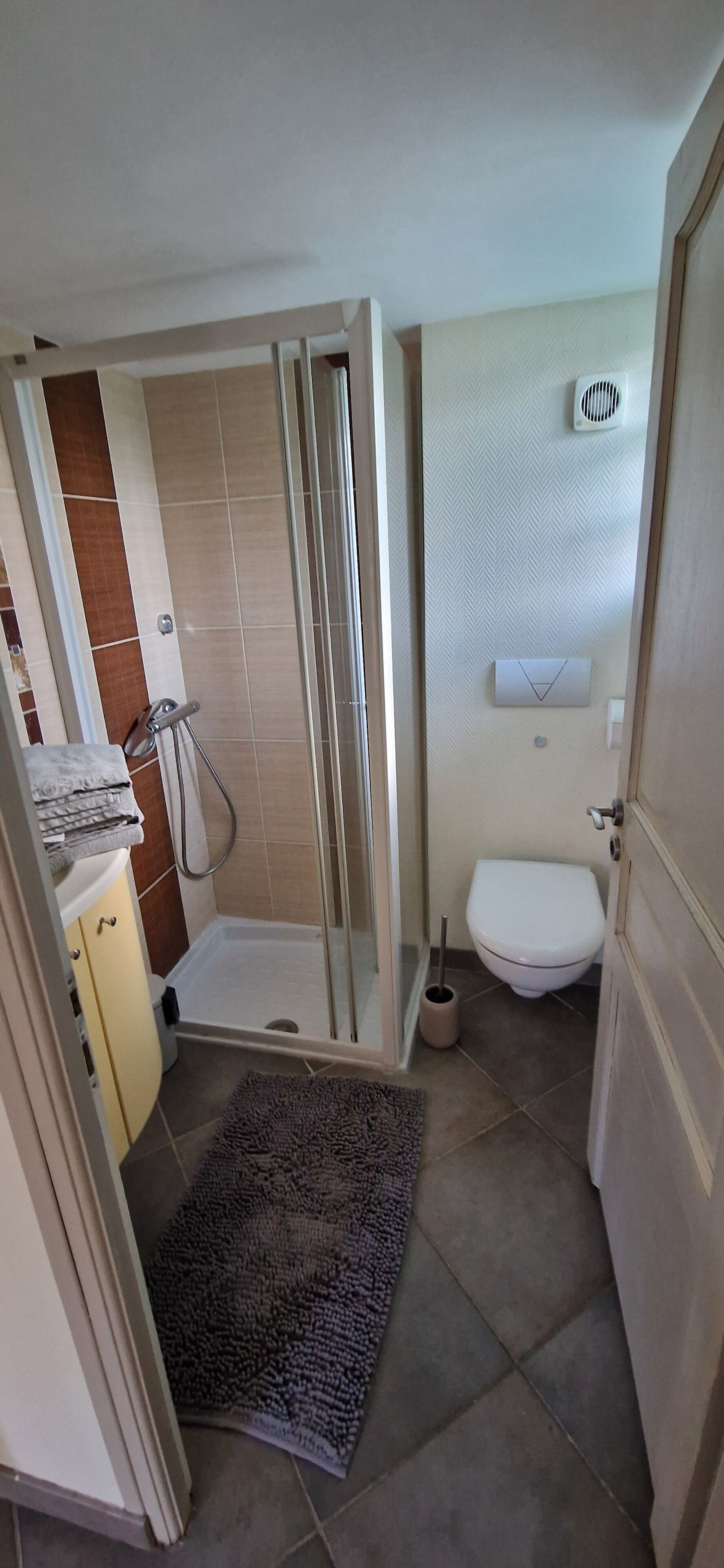 A bathroom with a shower, toilet, and sink.