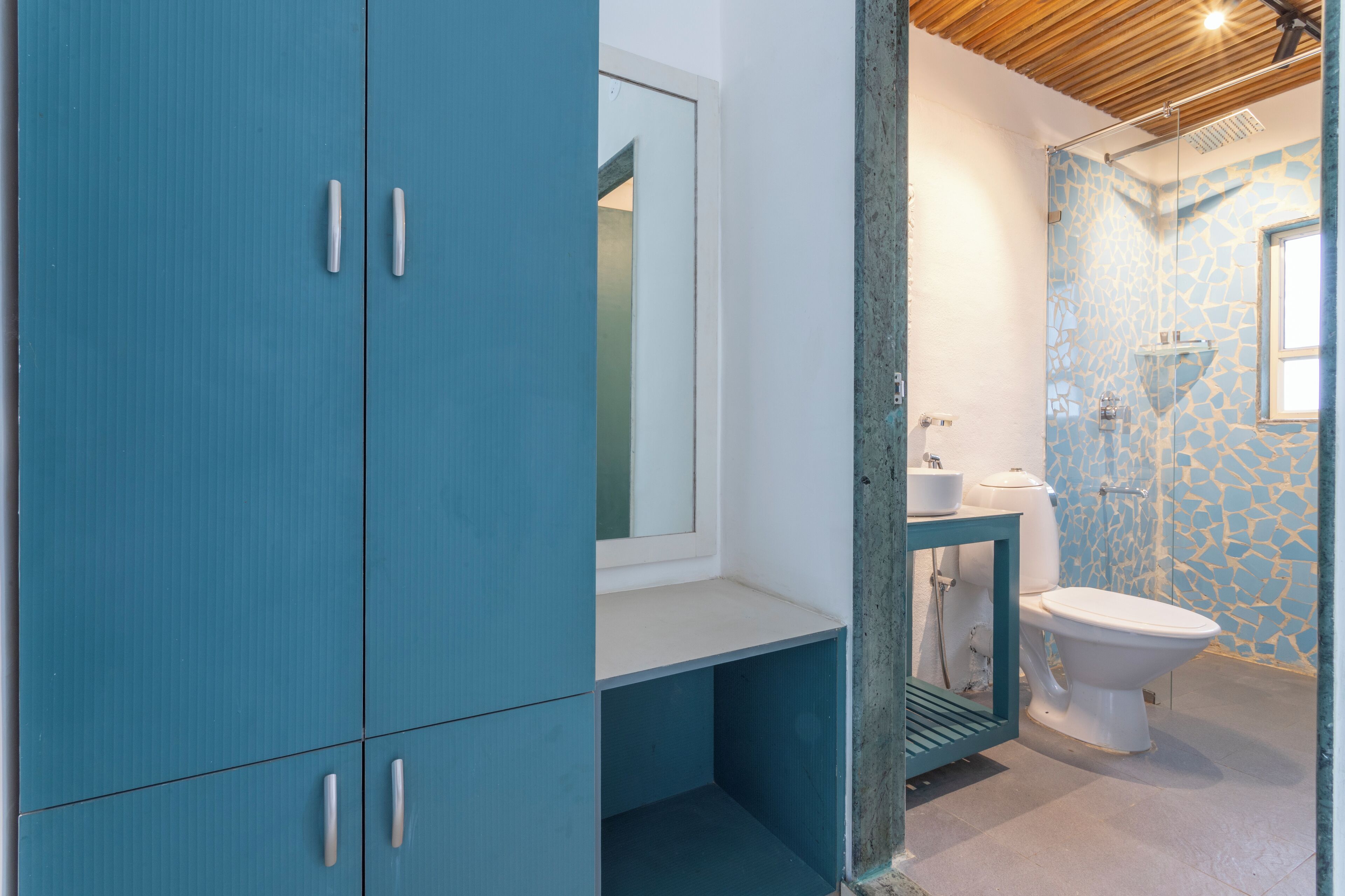 A bathroom with a blue cabinet, a white sink, and a toilet.