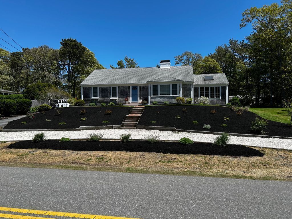 A two-story house with a front porch, a garage, and a landscaped front yard.