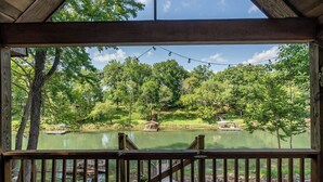 Une terrasse en bois offrant une vue sur un lac entouré d’arbres.