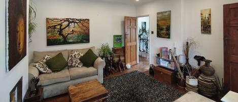 A living room with a sofa, coffee table, and artwork on the walls.