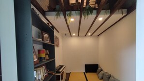 Une pièce comprenant un lit, une étagère avec des objets encadrés, un clavier et un haut-parleur.