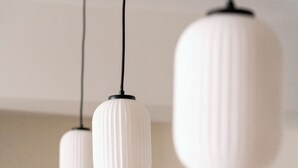 Kolme riippuvalaisinta, joissa on valkoiset, uurtekuvioidut varjostimet ja jotka roikkuvat mustista johdoista.