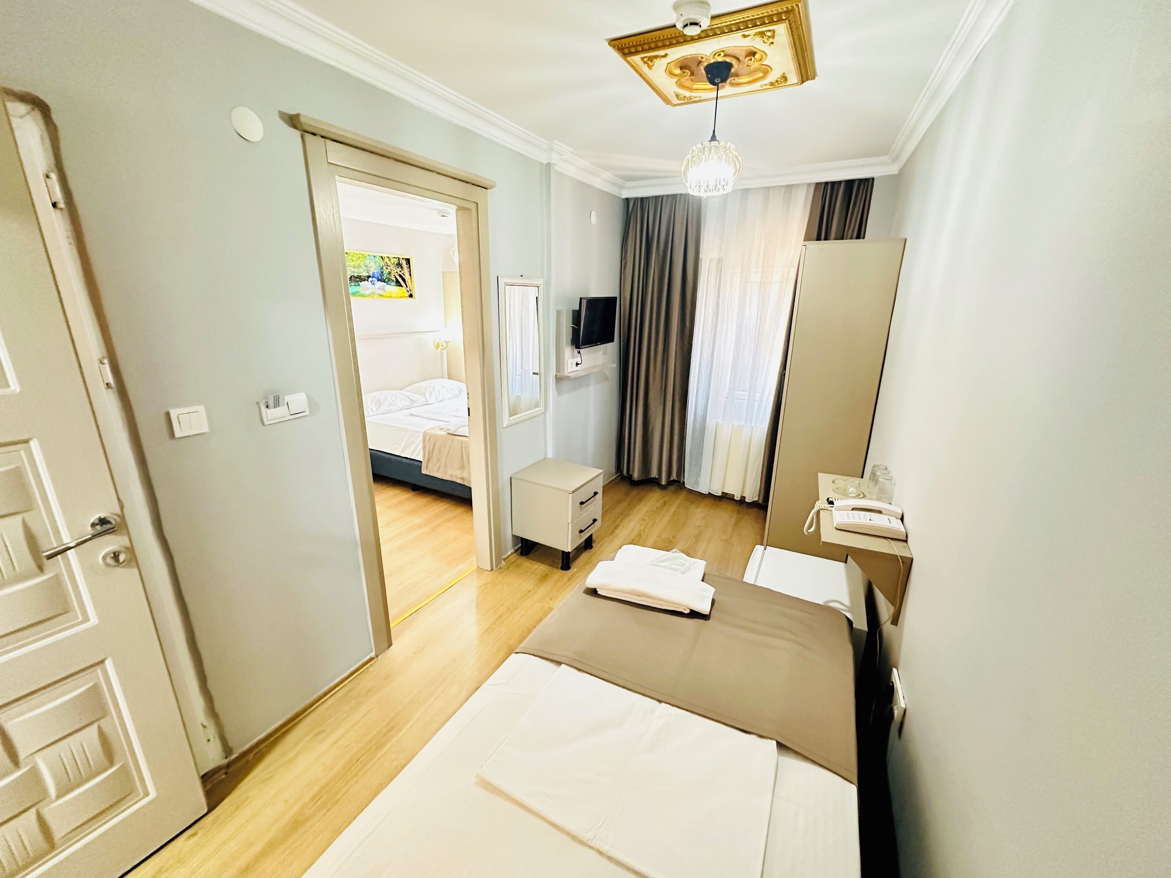 Une chambre d’hôtel équipée d’un lit, d’une table de chevet, d’un miroir et d’un téléviseur.