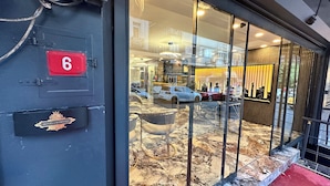 A hotel entrance with a glass facade, a red sign with the number 6, and a 'Hotel Crowned' logo. - Crowned Exclusive Hotel (Istanbul)