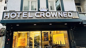 A hotel named "Hotel Crowned" with a modern facade, large windows, and a visible entrance with seating outside. - Crowned Exclusive Hotel (Istanbul)