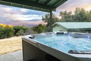 Un bain à remous avec vue sur les montagnes et les arbres.