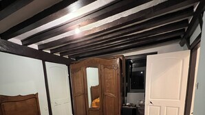 Een slaapkamer met een houten bed, een kledingkast en een radiator.