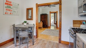 A kitchen with a wooden dining table, chairs, a stove, and a ceiling fan. - 3 Mi to Road America: Spacious Elkhart Lake Home! (Elkhart Lake)