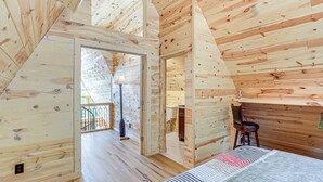Ein Holzblock-Interieur mit Schlafzimmer auf dem Dachboden, einem Essbereich und einem Badezimmer.