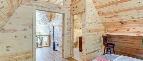 L’intérieur d’une cabane en bois comprend une chambre à coucher située en mezzanine, un coin repas et une salle de bain.