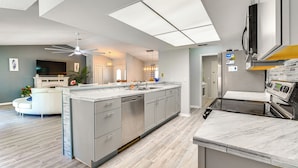 A modern kitchen with a large island, stainless steel appliances, and a ceiling fan. - Spring Hill Home: Heated Pool, 9 Mi to Beach! (Spring Hill)