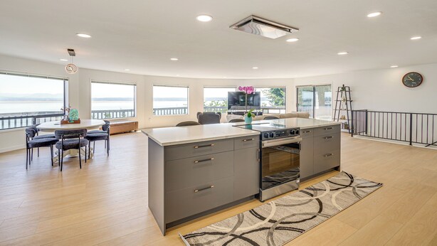 Una cocina moderna con una isla central, ventanas amplias y vistas al exterior.