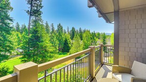 Ein Balkon mit Blick auf einen Wald und eine Straße.